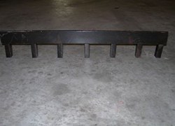 Gutter drain brush guard, a dark steel bar on short legs